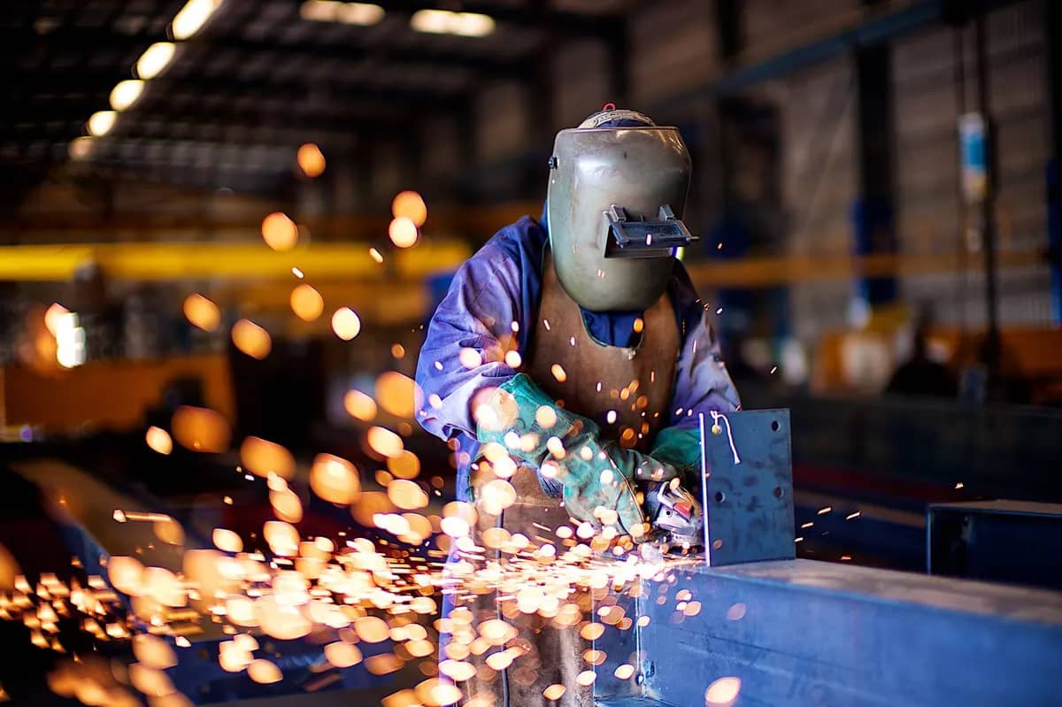 Koruyucu ekipmanla metal parça üzerinde kaynak çalışması